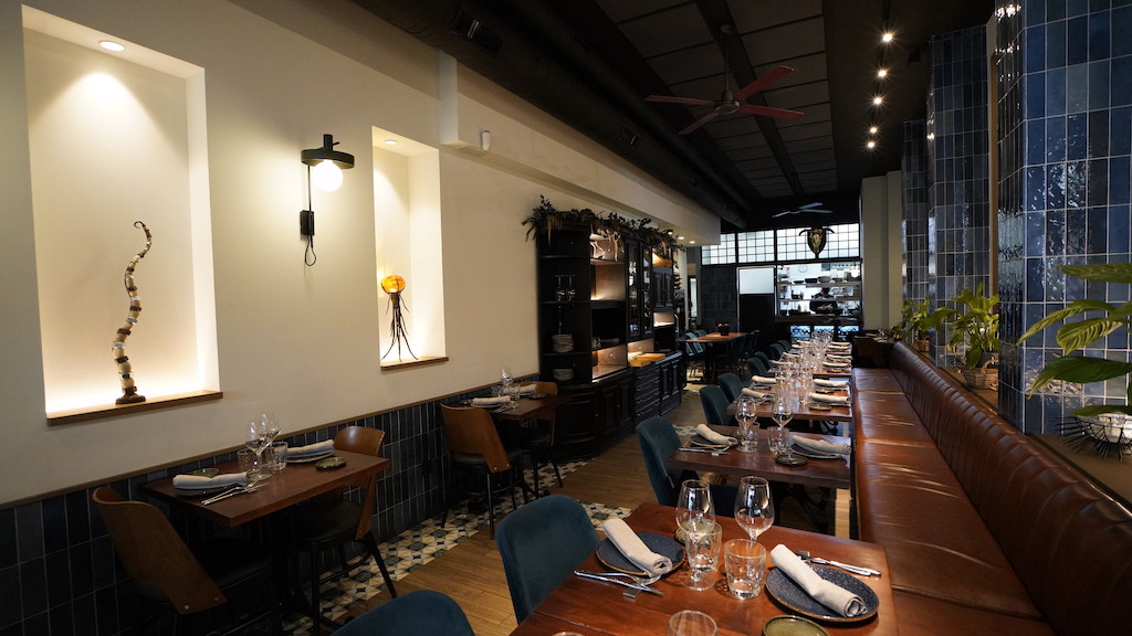 Comedor del restaurante Tragaldabas con cocina abierta